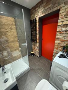 a bathroom with a shower and a toilet and a red door at Sunset Loft in Lubin +14 photos