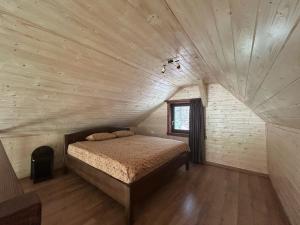 a bedroom with a bed in a wooden room at Cabana Cremenea in Merişor