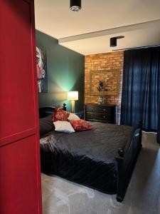 a bedroom with a black bed with red pillows at Sunset Loft in Lubin