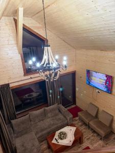 a living room with a couch and a chandelier at Cabana Cremenea in Merişor +18 photos