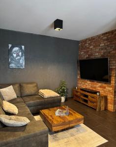 a living room with a couch and a flat screen tv at Sunset Loft in Lubin