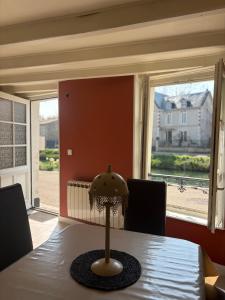 a lamp sitting on a table in a dining room at Maison bord de sèvre in Coulon