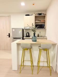 a kitchen with a counter and two stools at a kitchen island at Dcondo reef artificial pavement Prime location in Kathu