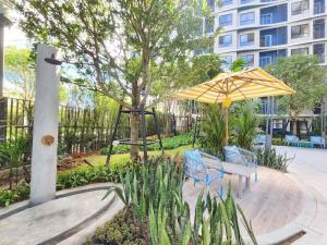 a park with two benches and an umbrella at Dcondo reef artificial pavement Prime location in Kathu