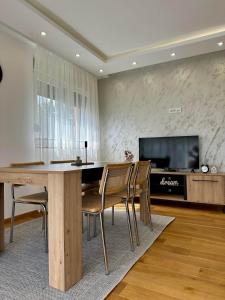 a dining room with a table and chairs and a tv at VIP House 5 in Vrnjačka Banja