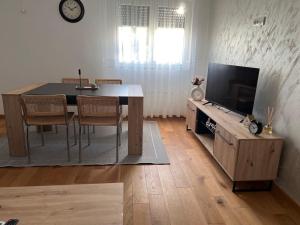 a living room with a table with chairs and a television at VIP House 5 in Vrnjačka Banja +2 photos