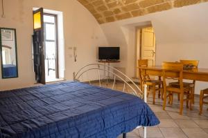 a bedroom with a bed and a table and a television at Chicca's Apartments Gallipoli in Gallipoli