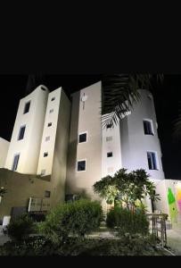 two white buildings with trees in front of them at محمد هوم in Al Hofuf