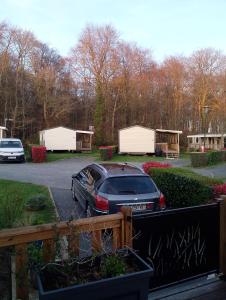 a car parked in a parking lot with white huts at Location mobil home in Litteau