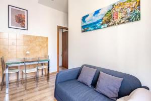 a living room with a blue couch and a table at Luminoso Appartamento con Balcone & ParcheggioFree in La Spezia +17 photos