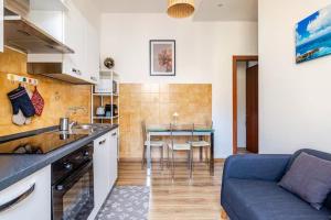 a kitchen and living room with a couch and a table at Luminoso Appartamento con Balcone & ParcheggioFree in La Spezia