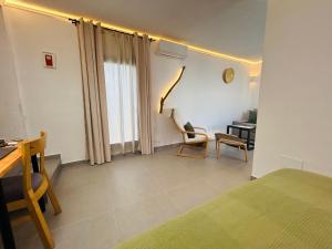 a bedroom with a bed and a desk and chairs at Smart Apartments Facinas, Piscina y tranquilidad cerca de Tarifa y Bolonia in Facinas +67 photos