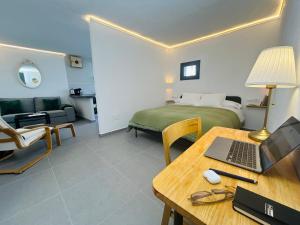 a room with a bed and a desk with a laptop at Smart Apartments Facinas, Piscina y tranquilidad cerca de Tarifa y Bolonia in Facinas