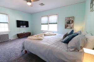 a large white bed in a room with windows at Lofty Elegant Home • Downtown Princeton • 3BR in Princeton
