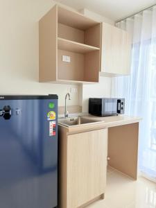 a small kitchen with a sink and a refrigerator at Dcondo Reef kathu Patong in Kathu