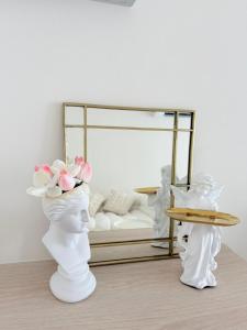 two white vases with flowers on them in a room at Dcondo Reef kathu Patong in Kathu +12 photos