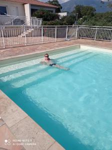 a man is swimming in a swimming pool at villa Montecristo in Cervione