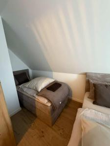 a small bedroom with a bed in the attic at Domek u Łowiszów in Dzianisz