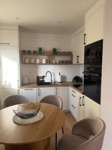 a kitchen with a wooden table with chairs and a tableasteryasteryasteryasteryastery at Domek u Łowiszów in Dzianisz