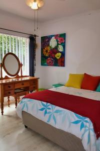 a bedroom with a bed and a mirror and a table at The Wilderness Way in Wilderness