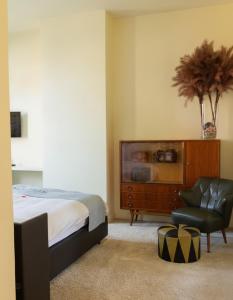a bedroom with a bed and a chair and a dresser at Central Bruges B&B in Bruges
