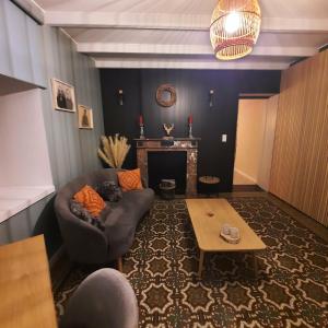 a living room with a couch and a table at Au doux gîte in Bras-Haut