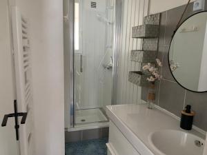 a bathroom with a sink and a shower with a mirror at Marieno in Barbâtre +4 photos