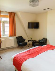 a bedroom with a bed and two chairs and a tv at Central Bruges B&B in Bruges
