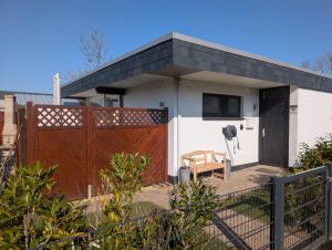a small house with a gate and a fence at Ferienhaus LouJa in Butjadingen