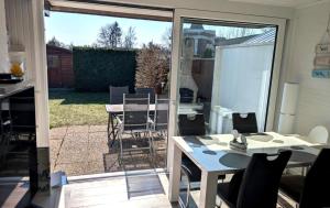 an open patio door with a table and chairs at Ferienhaus LouJa in Butjadingen +14 photos