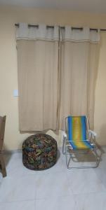 a chair and a ottoman in front of a window at Kitnet Praia de Alagoinhas in Fortaleza