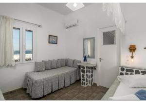 a living room with a couch and a window at Stella's Mandrakia Seaside House in Mandrakia