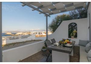 a patio with a table and a view of the ocean at Stella's Mandrakia Seaside House in Mandrakia