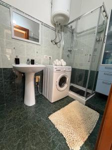 a bathroom with a washing machine next to a sink at Grazia's Heaven in Trezzo sullʼAdda