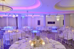 a banquet hall with white tables and chairs at Ajax Hotel in Limassol +113 photos