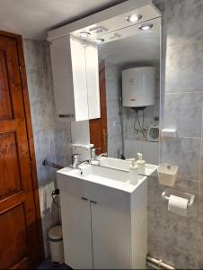 a bathroom with a white sink and a mirror at Kucica Yuva in Vrnjačka Banja +35 photos