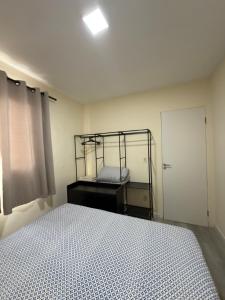 a bedroom with a bed and a window and a door at Espaço Parque das Gaivotas in Vila Velha