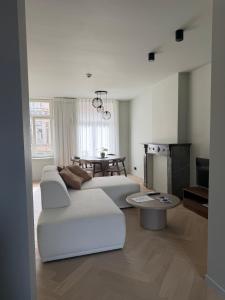 a living room with a white couch and a table at Allies Avenue in Leuven