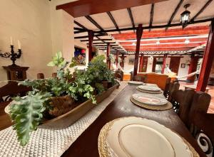 a dining room with a table with plates and plants at La Franchesca Hotel Boutique in Tabio
