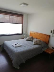 a bedroom with a large bed with a large window at Hotel Bello, Andrés Bello 1166 in Temuco