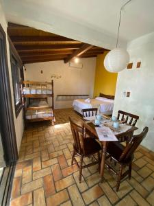 a room with a table and chairs and two bunk beds at Pousada Vila Maria in Garopaba +60 photos