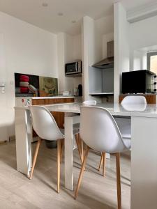 a dining room with a white table and chairs at CASA TULUM in Cognac