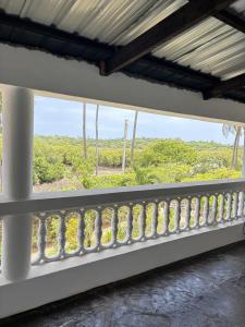 a balcony with a view of the ocean at Mango House Watamu in Watamu