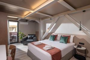 a bedroom with a large bed and a chair at Infinity City Boutique Hotel in Heraklio