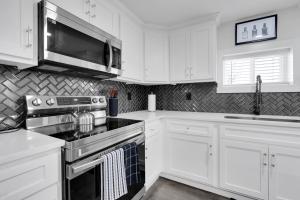 a kitchen with white cabinets and a stove and a microwave at Lounges at Lynchburg in Lynchburg