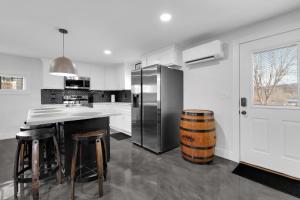 a kitchen with a refrigerator and a counter with stools at Lounges at Lynchburg in Lynchburg