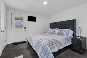 a bedroom with a bed with a black headboard and a window at Lounges at Lynchburg in Lynchburg