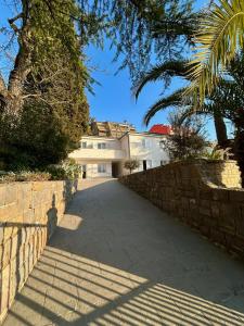 a driveway leading to a house with a stone wall at Porto MarIn Strašek in Portorož