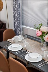 a table with plates and glasses and a vase of roses at Endless Sunset- Near Beach Surf and Pet Friendly in Huntington Beach +55 photos