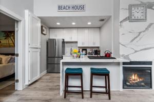 a kitchen with a bar with two stools and a fireplace at Endless Sunset- Near Beach Surf and Pet Friendly in Huntington Beach